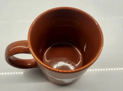 Brown ceramic coffee mug with handle featuring University of Texas Longhorns logo