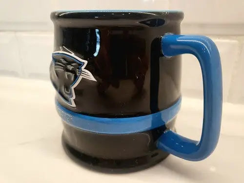 Black Carolina Panthers ceramic coffee mug with blue accents and black 3D sculpted logo