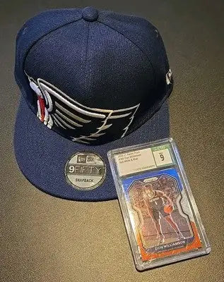 Navy New Orleans Pelicans baseball cap and Zion Williamson graded card featuring NBA star