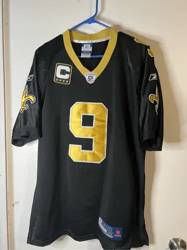 Black and gold Orleans Saints Drew Brees jersey with stitched number 9 front view