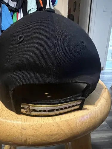 Black New Orleans Saints NFL hat with gold and black striped adjustable strap