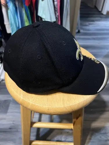 Black New Orleans Saints NFL hat with gold fleur-de-lis logo for fans