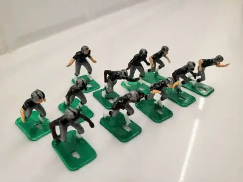 Toy football players on green bases from NFL 1970s Oakland LA Raiders set