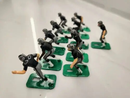 Toy football players from NFL 1970s featuring Oakland LA Raiders design in new black paint