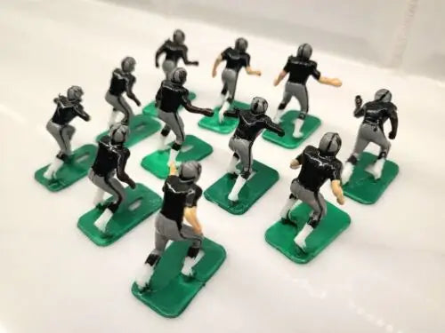 Toy football players from NFL 1970s featuring Oakland LA Raiders design in black paint