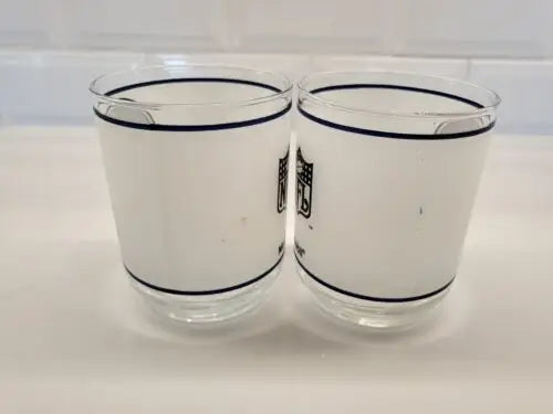 Two frosted NFL glasses featuring Dallas Cowboys frosted helmet logo drinking glasses