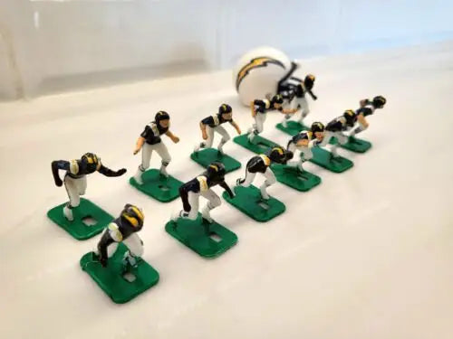 Toy football players and helmet showcasing San Diego Chargers electronic football game