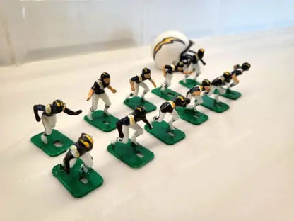 Toy football players and helmet showcasing San Diego Chargers electronic football game