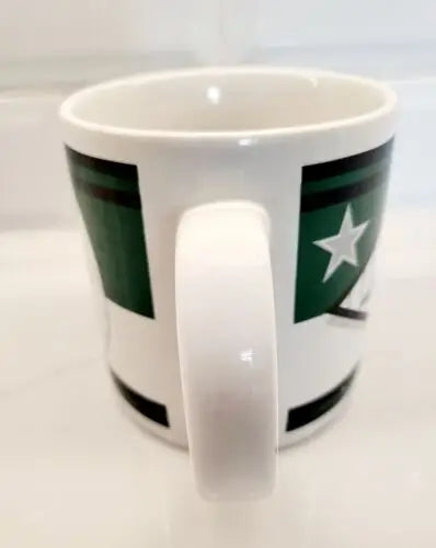 White ceramic coffee mug with green star design featuring York Jets logo
