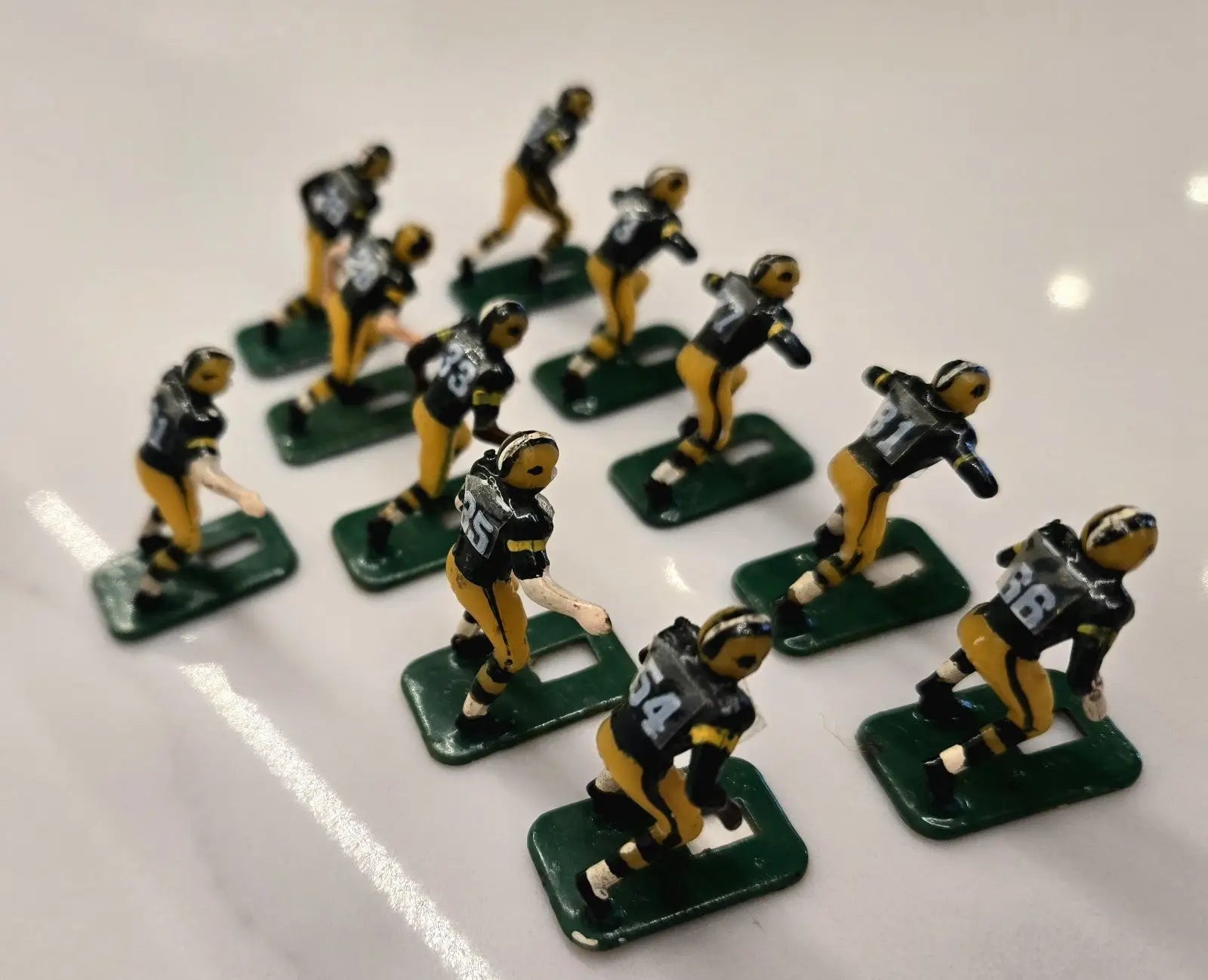 Vintage metal football figurines of Green Bay Packers NFL Tudor players displayed elegantly