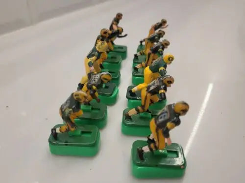 Vintage electric football figures featuring Green Bay Packers players with stands