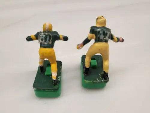 Two vintage Green Bay Packers electric football figures in custom stands