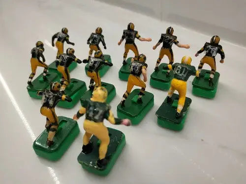 Miniature Green Bay Packers football figures on green bases with custom stands