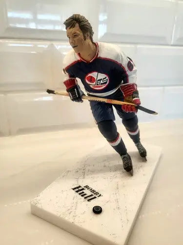 Bobby Hull hockey figurine wearing Winnipeg Jets blue uniform with repaired arm