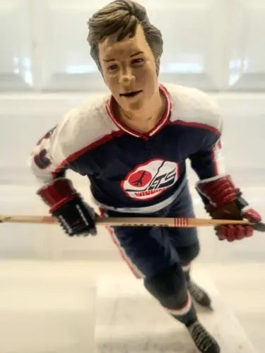 Hockey player figurine of Bobby Hull in NHL Winnipeg Jets blue uniform with repaired arm