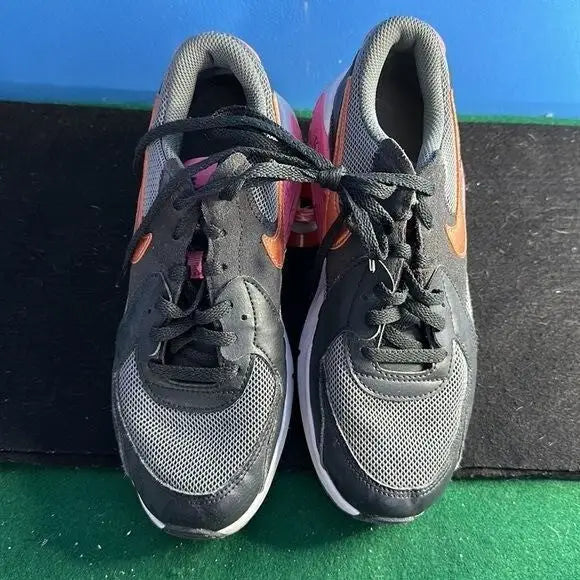 Nike Air Max Excee youth athletic sneakers in black, gray, and orange with black laces