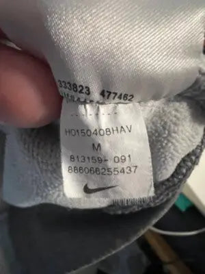 Nike Heather Gray Pullover Hoodie apparel care tag showing washing instructions