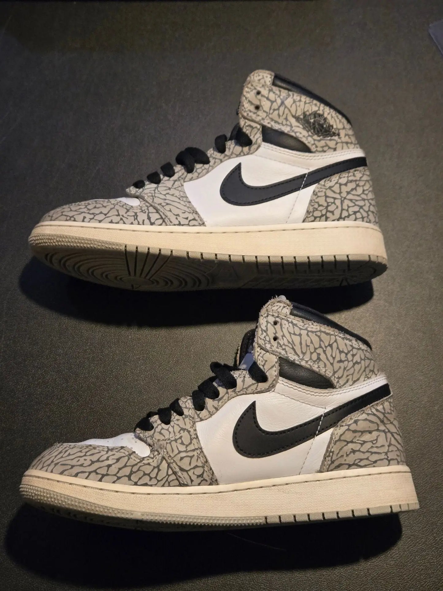 Two pairs of Nike Jordan Air leather high-top sneakers with gray, white, and elephant print