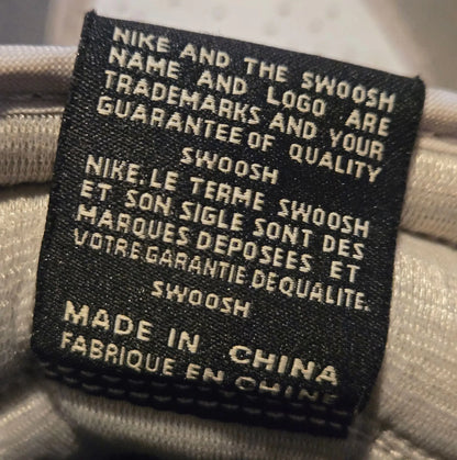 Black fabric Nike product tag with white text on Nike Jordan Air Leather Shoes with elephant print