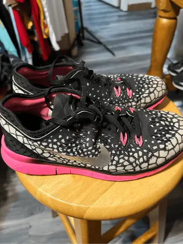 Nike True Fit athletic shoes with black and white pattern, hot pink soles and accents