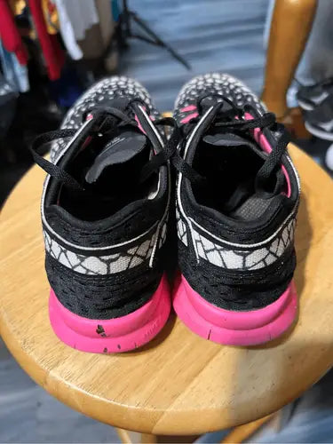 Nike True Fit athletic shoes with black and white design and bright pink soles