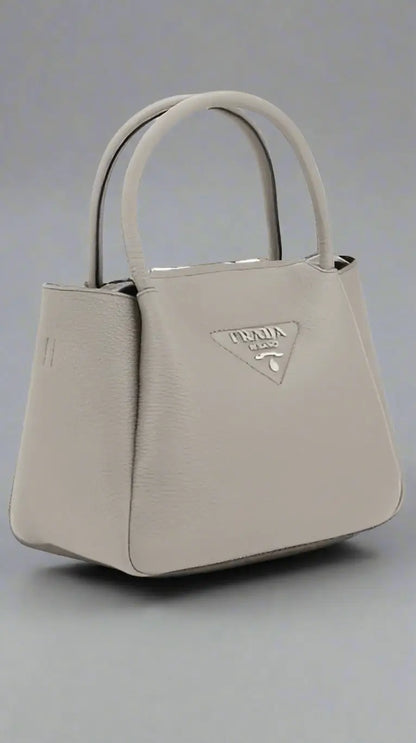 Light gray grained leather tote bag with two top handles at PRADA women’s handbag