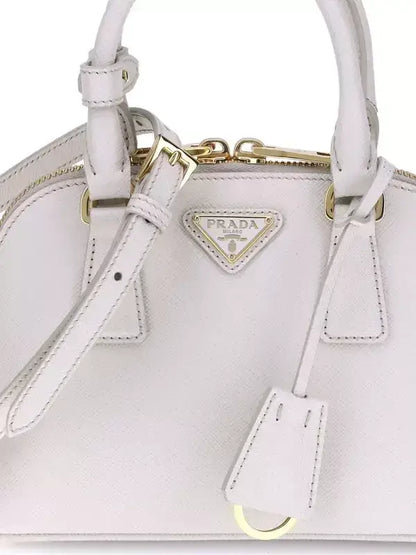 Light pink Prada leather handbag with gold hardware, logo patch, and zip closure