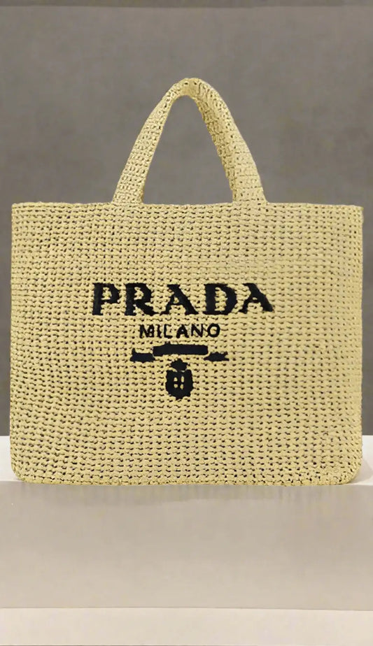 Beige PRADA woven raffia shopping handbag with black embroidered text and emblem