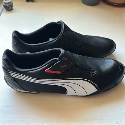 Black Puma Rendon Move men’s sneakers with synthetic leather upper, white stripes, and red accents