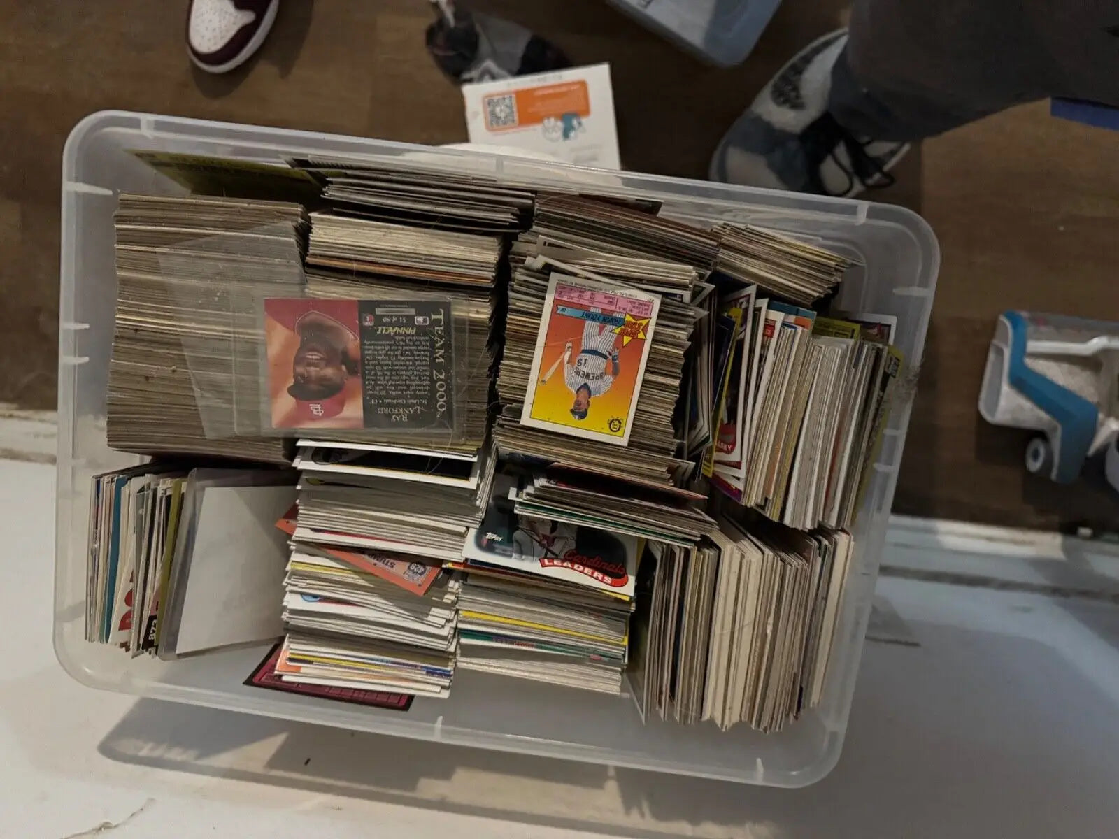 White plastic storage bin filled with various graded trading cards and sports cards