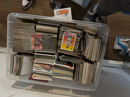 White plastic storage bin filled with various graded trading cards and sports cards