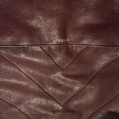 Close-up of relic brown faux leather handbag with chevron stitching design