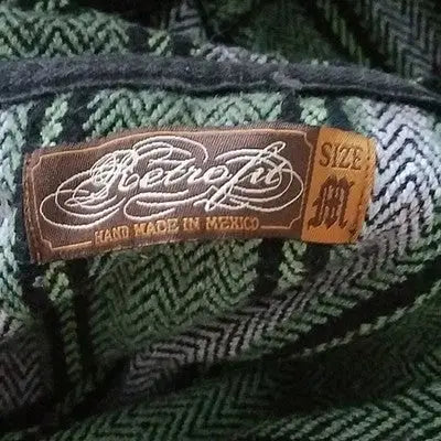 Brown Retrofit clothing label with handmade Mexico and size medium on green and black herringbone fabric