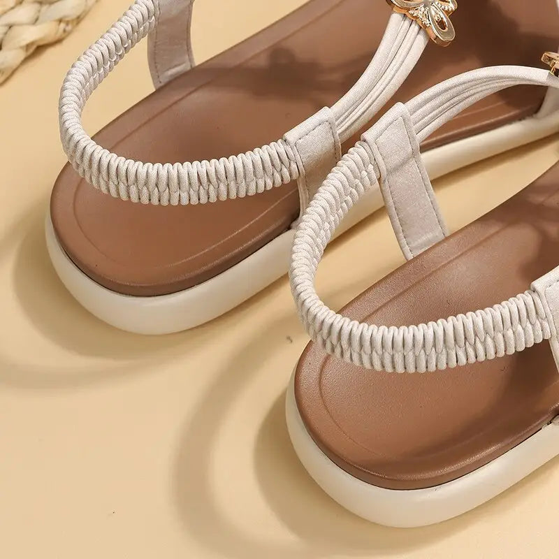 Roman style flat sandals for women with white elastic straps and brown insoles