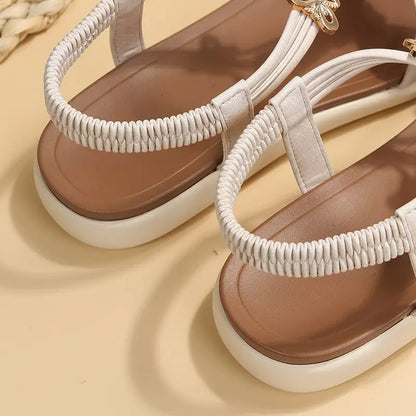 Roman style flat sandals for women with white elastic straps and brown insoles