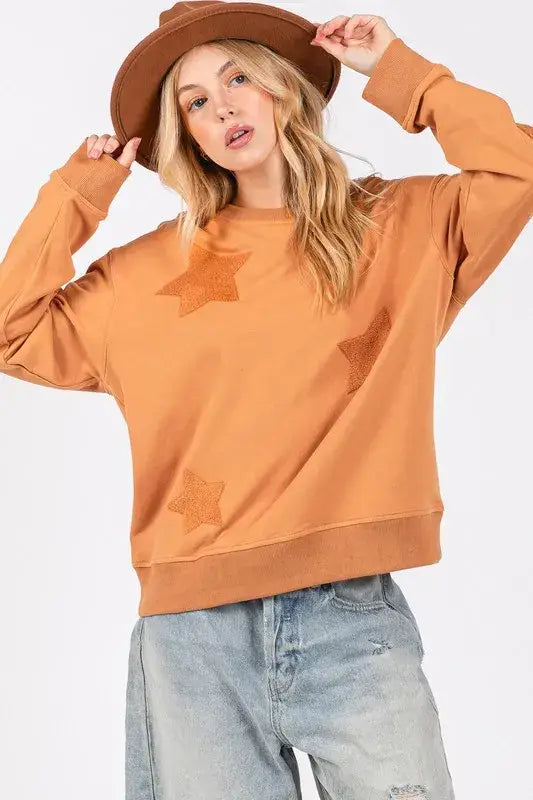 Rust-colored Sage + Fig Star Patch Long Sleeve Sweatshirt with ribbed cuffs and hem