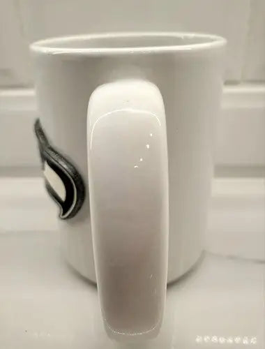 White ceramic coffee mug with handle featuring Seattle Seahawks NFL football raised logo