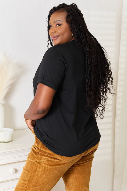 Black short-sleeved top with round neck and kind graphic design paired with mustard corduroy pants