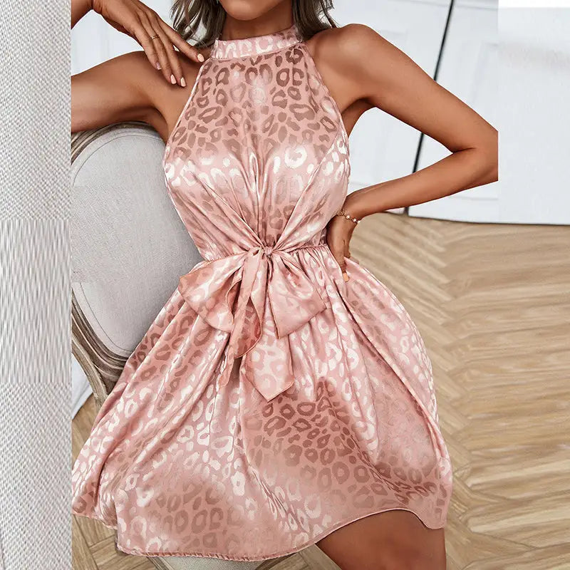 Pink satin sleeveless halter neck dress with leopard print and front bow for stylish occasions