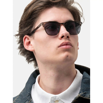 Young man wearing Smooder sunglasses with denim jacket and white polo shirt