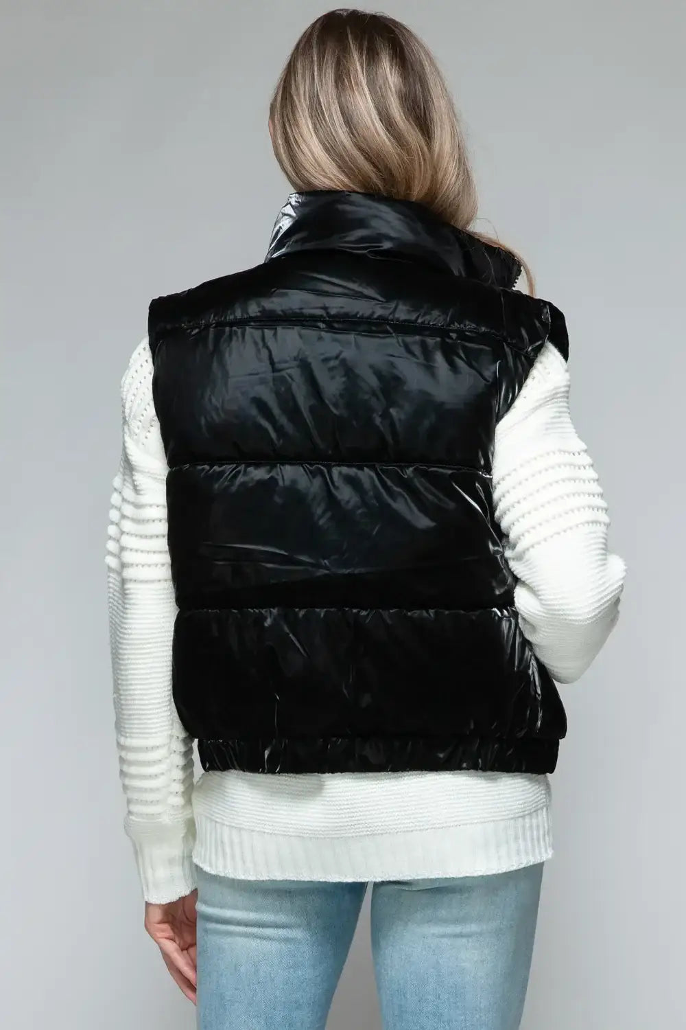 Black quilted puffer vest with white ribbed trim and fine fur lining for warmth