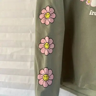 Olive green long-sleeved Stella Tweed pullover hoodie with pink daisy flowers and smiley faces