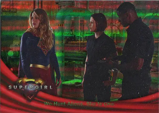 Three people with one in a blue superhero costume beside Rainbow Foil Board Card 06