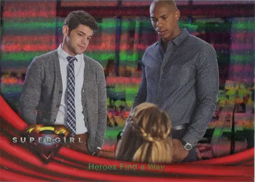 Two men in business attire with Supergirl Season 1 Rainbow Foil Board backdrop
