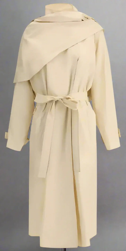 Long beige Donette trench coat with asymmetrical storm flap and matching tie belt