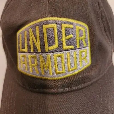 Dark grey Under Armour hat cap with yellow and grey embroidered logo for a stylish armour hat