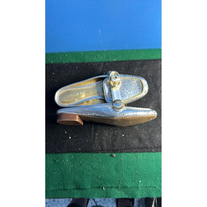 Silver women’s flat mule shoes with brown heel and buckle, perfect for stylish gold loafers