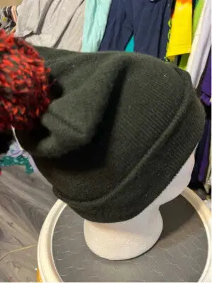 Black knit beanie with red and black pom-pom featuring Harley Quinn logo for Batman DC Comics fans
