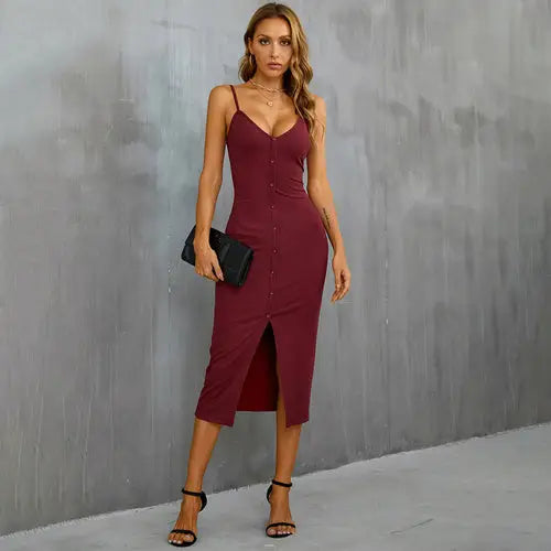 Woman in burgundy V-neck split bodycon holiday party dress with black clutch and heels