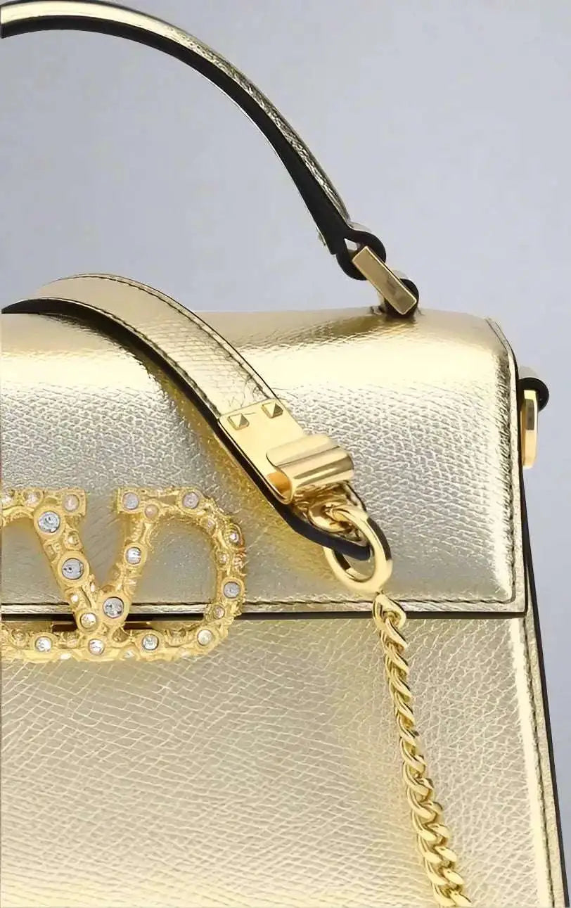 Valentino Garavani mini handbag in metallic garnet leather with gold chain strap and VD logo